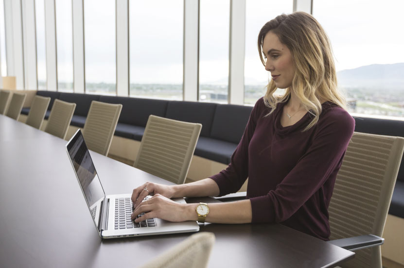 Person Working on Laptop in Conference Room